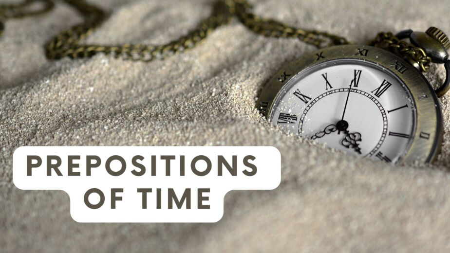 a watch in sand showing the time 3:35 a and the text prepositions of time