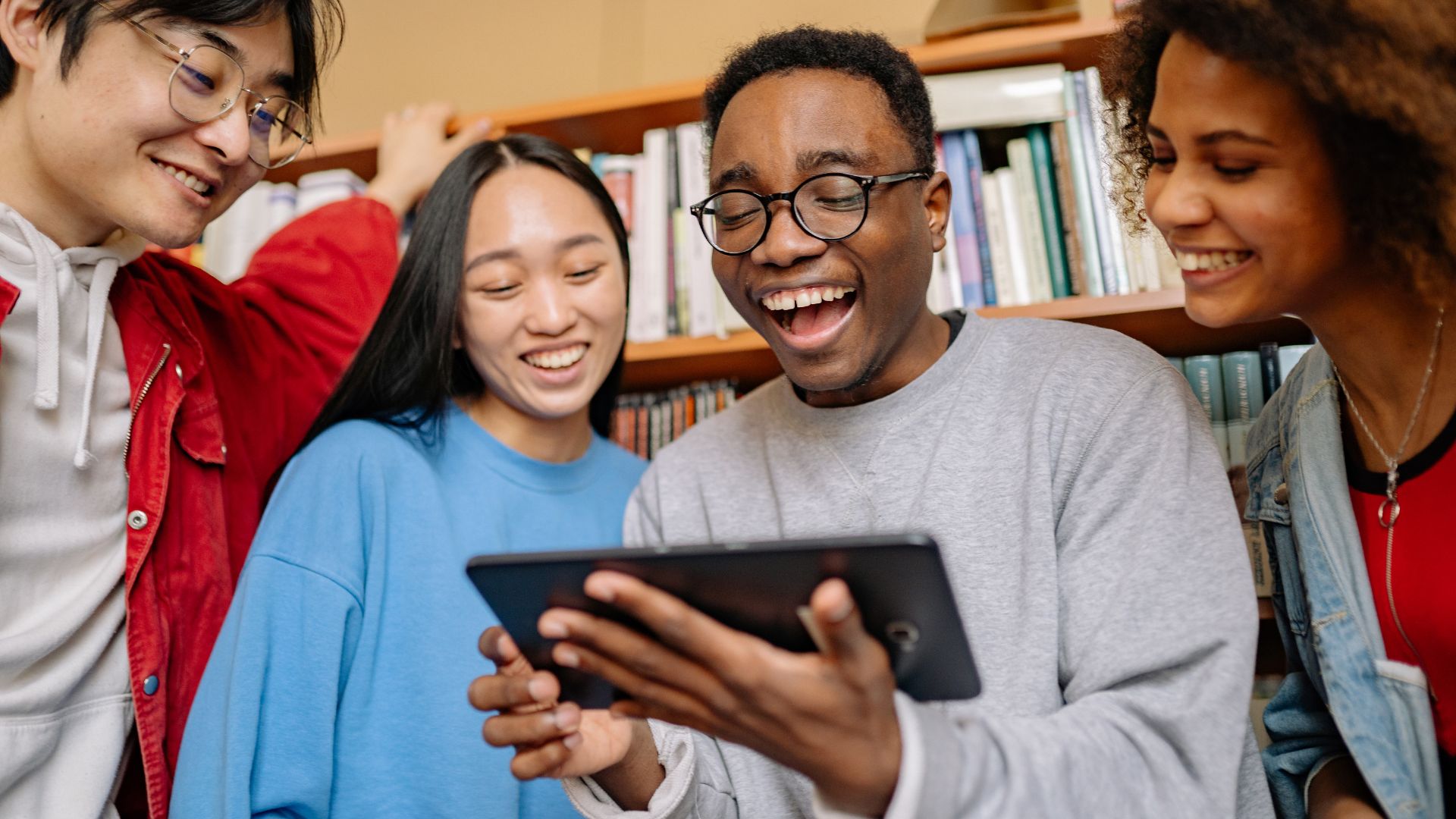group of friends watch lovely english stories on theiur ipad
